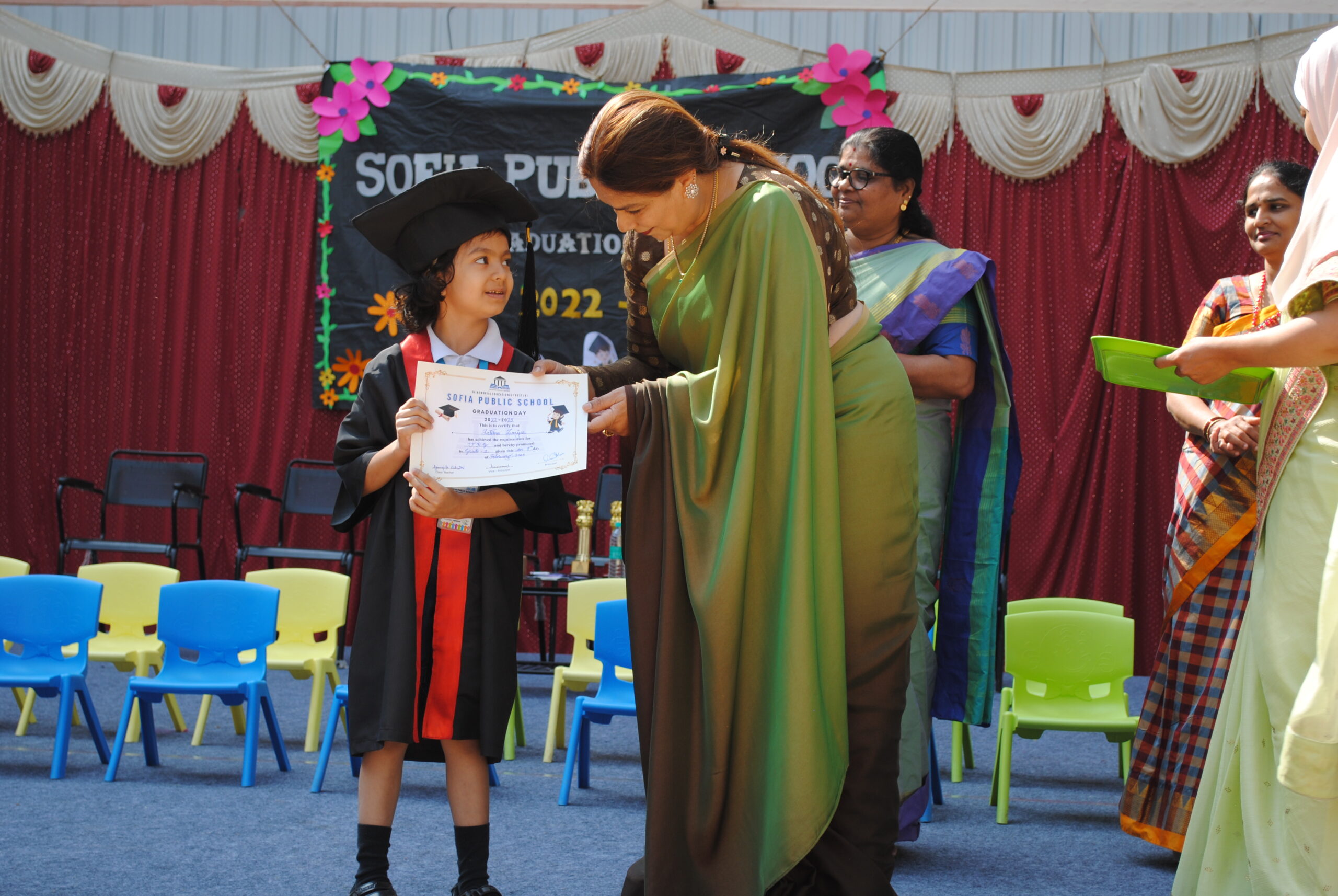 Child being given an award and praise for graduating class.